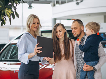Die junge Familie unterzeichnet das von Autoankauf Bergisch Gladbach fertiggestellte Angebot