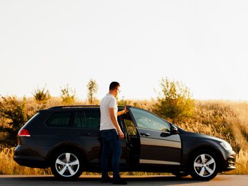 Mann steigt in sein zu verkaufendes Gebrauchtwagen ein